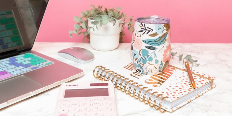 Escritorio con portátil y calculadora para comparar WooCommerce y Shopify